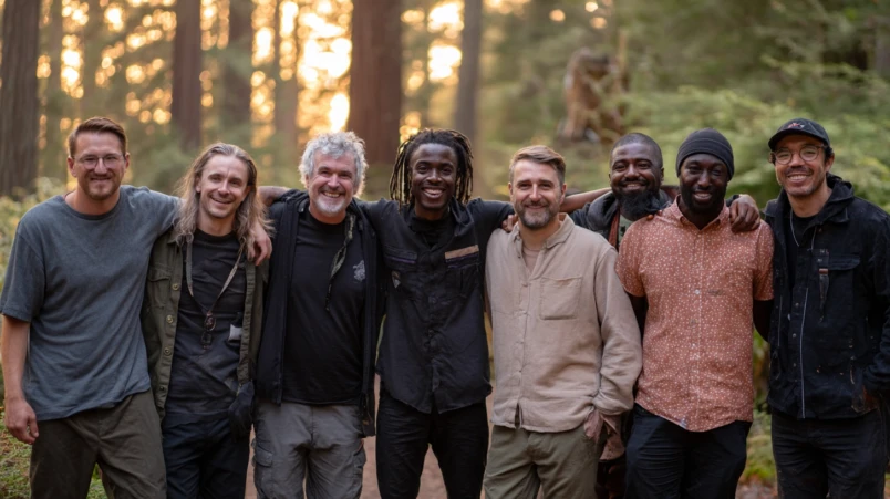 En grupp glada män som står arm i arm utomhus, symboliserar ett starkt team för en svensexa.