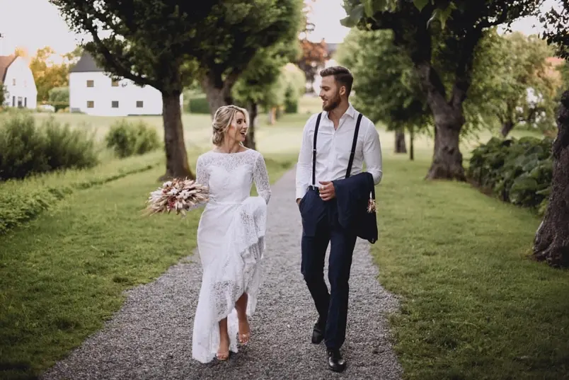 Bröllopspar som går på grusgång innan vigsel