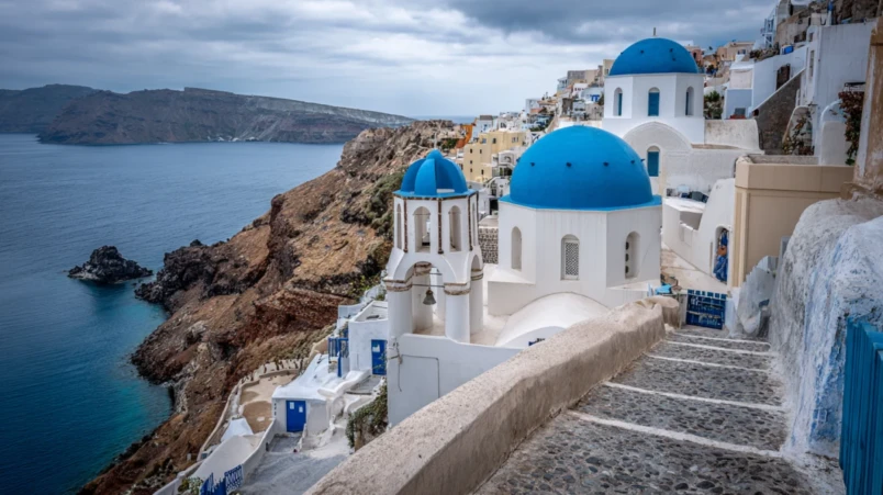 Vitkalkade hus med blå kupoler på Santorini i Grekland för bröllopsresa