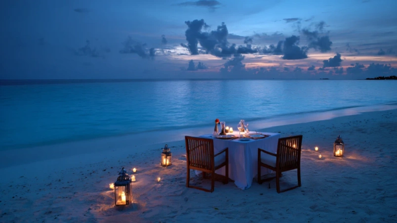 Romantisk honeymoon-middag på stranden vid en resort på Maldiverna