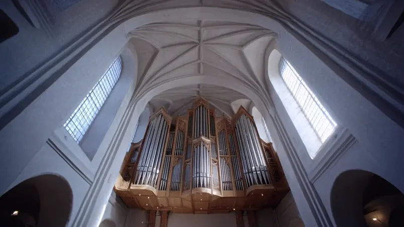 Kyrkorgel i en svensk kyrka med pipor som sträcker sig mot taket, redo för utgångspsalm