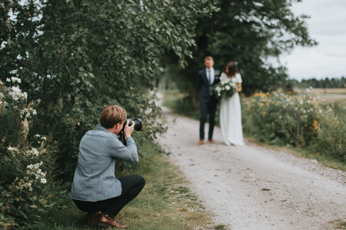 Bröllopsfotograf som fotograferar ett brudpar utomhus