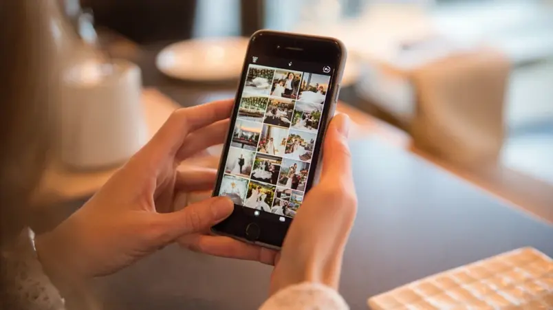 Par som scrollar genom en bröllopsfotografs Instagram på en mobiltelefon
