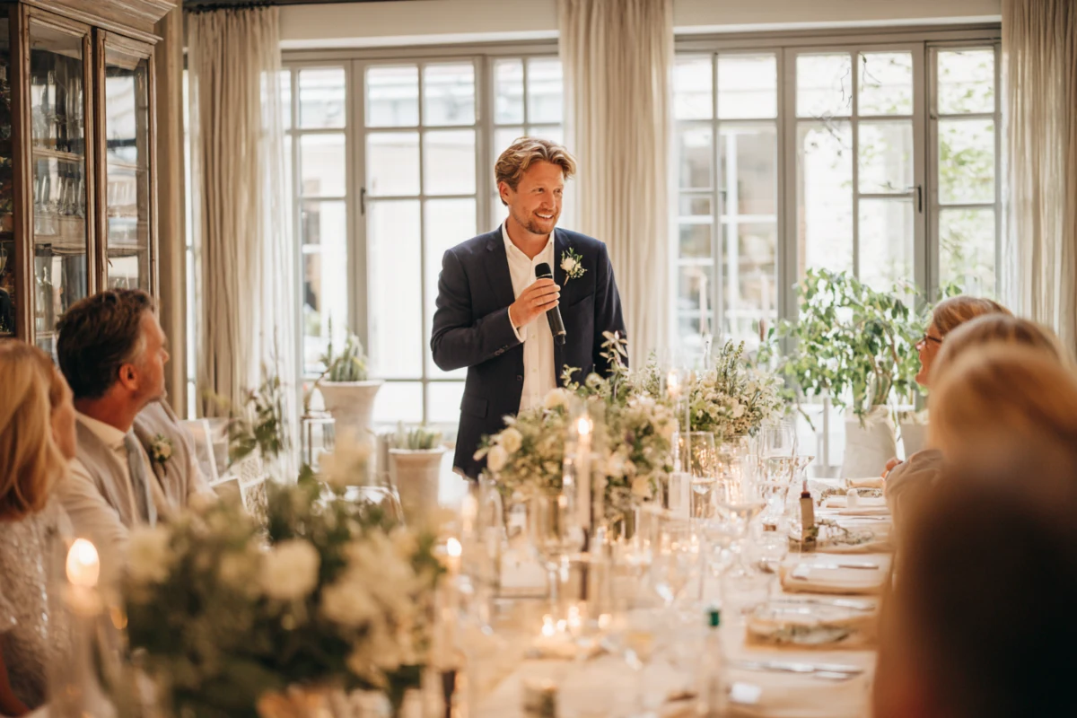 Bröllopsmiddag med gäster som lyssnar på tal vid dukat bord