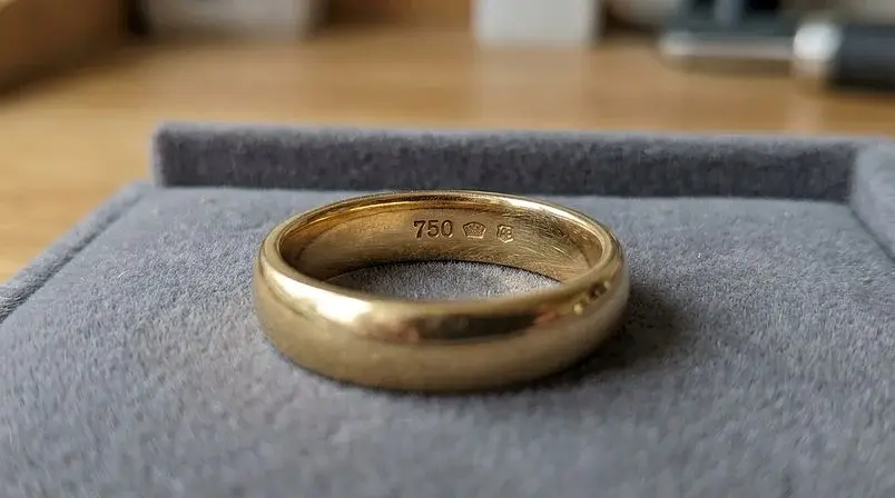 Närbild på insidan av en guldring med finhaltsstämpeln 750